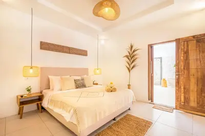 a bedroom with a large bed and a large window at Villa Tokyo - 3 BDR Private Villa - 3 min walk to KU DE TA beach in Kuta