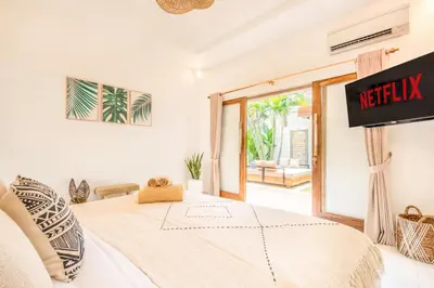 a bedroom with a bed and a exit to a patio at Villa Tokyo - 3 BDR Private Villa - 3 min walk to KU DE TA beach in Kuta