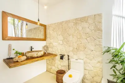 a bathroom with a toilet and a mirror at Villa Tokyo - 3 BDR Private Villa - 3 min walk to KU DE TA beach in Kuta