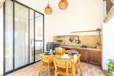 a dining room with a wooden table and chairs at Kamaratih Villas by Maheswara in Legian