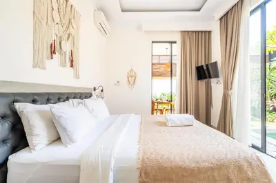 a bedroom with a large bed with white pillows at Kamaratih Villas by Maheswara in Legian