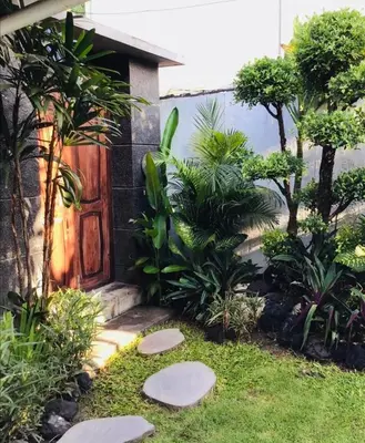 a garden with stepping stones in front of a door at Luka Villas - Luxury 2 Bedroom Private Pool Villa in Seminyak