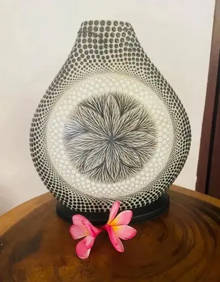 a vase sitting on a table with a pink flower at Luka Villas - Luxury 2 Bedroom Private Pool Villa in Seminyak