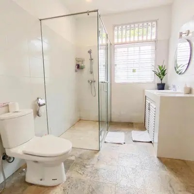 a bathroom with a shower and a toilet and a sink at Miracle Villa Sanur in Sanur
