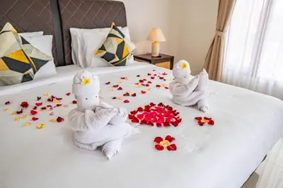 a bed with two towels and flowers on it at Villa Akmali Seminyak Basangkasa- 2 Bedrooms in Seminyak