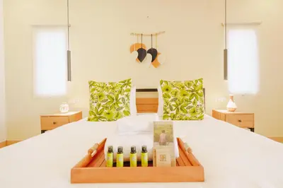 a bed with a tray of wine bottles on it at Villa Orked 3 with family room Seminyak in Seminyak