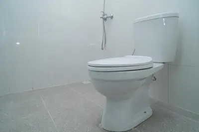 a white toilet in a bathroom with a shower at RedDoorz @ Jalan Gunung Talang Mahendradatta in Kerobokan
