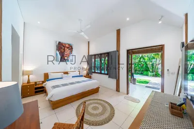 a bedroom with a bed and a table at Villa Kainara Seminyak by RPM in Seminyak