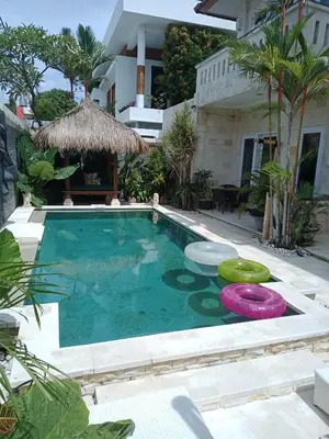 a swimming pool with two frisbees in front of a house at Villa Filo's Paradise Pool n Spa. Seminyak in Seminyak