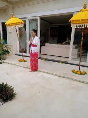a woman in a red dress standing under an umbrella at Villa Filo's Paradise Pool n Spa. Seminyak in Seminyak
