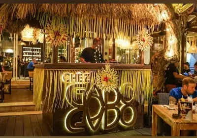 a restaurant with a bar with people sitting at tables at Villa Filo's Paradise Pool n Spa. Seminyak in Seminyak