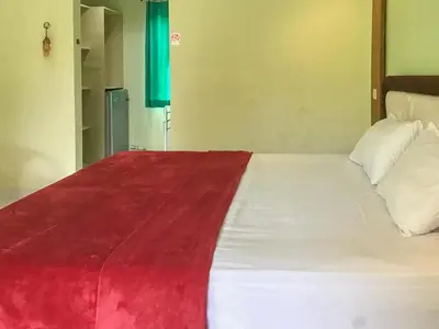 a large bed with a red and white blanket on it at Pondok Mesari Padma Legian RedPartner in Legian