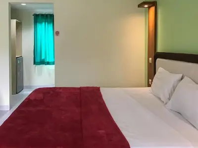 a bedroom with a bed with a red blanket on it at Pondok Mesari Padma Legian RedPartner in Legian