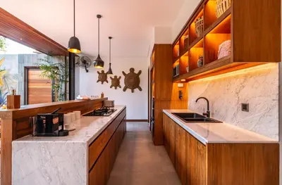 a kitchen with wooden cabinets and a counter top at PROMO Luxury 4bd Villa in HotSpot with Huge Private Pool in Seminyak