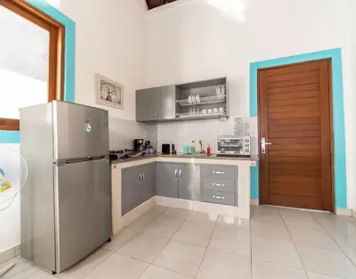 a kitchen with stainless steel appliances and a refrigerator at Spacious and Quiet 2 Bd Villa with Pool and Projector in Kerobokan