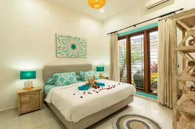 a bedroom with a bed with a flower on it at Spacious and Quiet 2 Bd Villa with Pool and Projector in Kerobokan