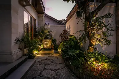 a courtyard of a house with a tree and lights at Spacious and Quiet 2 Bd Villa with Pool and Projector in Kerobokan