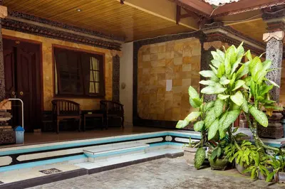 a house with a swimming pool in a yard at Segara Sadhu Inn Kuta by ecommerceloka in Kuta