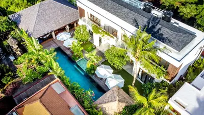 an aerial view of a resort with a pool and palm trees at Villa Nikaia by Villa Finder in Seminyak
