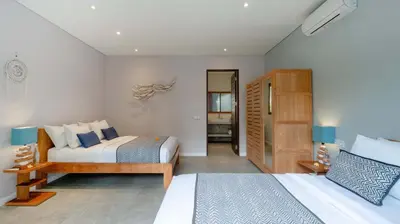 a bedroom with two beds and a room with at Villa Nikaia by Villa Finder in Seminyak