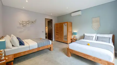 a bedroom with two beds and a room at Villa Nikaia by Villa Finder in Seminyak