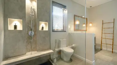 a bathroom with a toilet and a glass shower at Villa Nikaia by Villa Finder in Seminyak