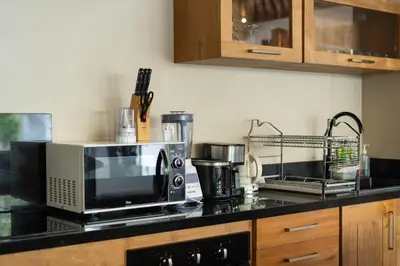 a kitchen counter with a microwave and a coffee maker at Villa Nikaia by Villa Finder in Seminyak