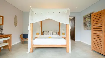 a bedroom with a bed with a canopy at Villa Nikaia by Villa Finder in Seminyak