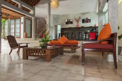 a living room with orange furniture and a fireplace at Villa Liang by Nagisa Bali in Seminyak