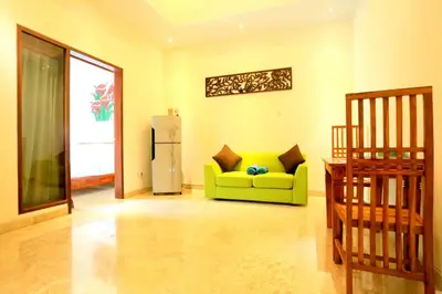 a living room with a yellow couch and a refrigerator at Jas Green Villas and Spa in Seminyak