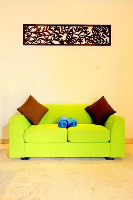 a green couch with two blue bows on it at Jas Green Villas and Spa in Seminyak