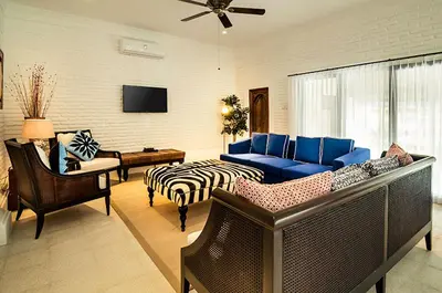 a living room with a blue couch and a zebra patterned couch at The Indies Estate in Sanur