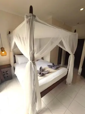 a white bed with a canopy in a room at Pondok DEWI Villa - LEGIAN - 6 Bedroom Villa - Great Location in Legian