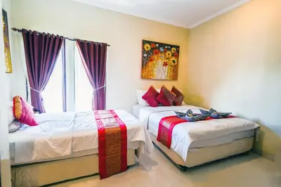a bedroom with two beds and a window at Pondok DEWI Villa - LEGIAN - 6 Bedroom Villa - Great Location in Legian