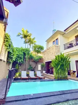 a swimming pool in front of a house at Pondok DEWI Villa - LEGIAN - 6 Bedroom Villa - Great Location in Legian