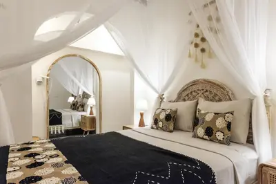 a bedroom with a large bed with a large mirror at Madeira Javanese Joglo, Jimbaran in Jimbaran