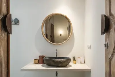 a bathroom with a bowl sink and a mirror at Madeira Javanese Joglo, Jimbaran in Jimbaran