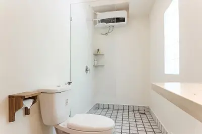 a white bathroom with a toilet and a sink at Madeira Javanese Joglo, Jimbaran in Jimbaran