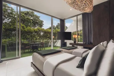 a bedroom with three beds and a large window at Monolocale Resort & Spa Seminyak by Ini Vie Hospitality in Seminyak