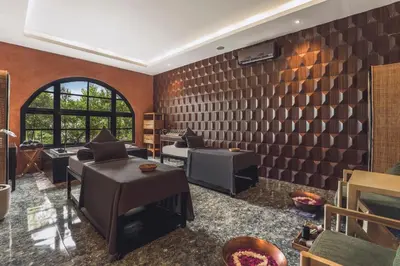 a living room with brown brick walls and couches at Monolocale Resort & Spa Seminyak by Ini Vie Hospitality in Seminyak
