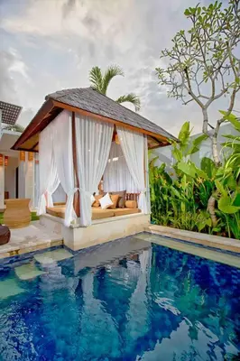 a gazebo sitting next to a swimming pool at THE MILAGRO VILLA in Canggu