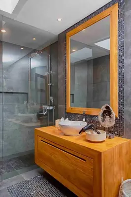 a bathroom with two sinks and a mirror and a shower at THE MILAGRO VILLA in Canggu