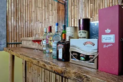 a wooden table with bottles and glasses of wine at Kuta EcoStay in Kuta