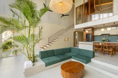 a living room with a green couch and a table at ASAI Village in Jimbaran