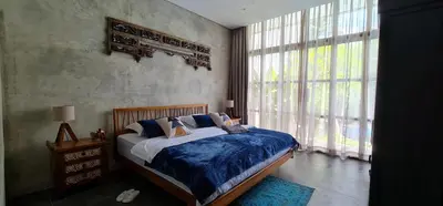 a bedroom with a bed and a large window at Rumah Hadeka Petitenget in Seminyak