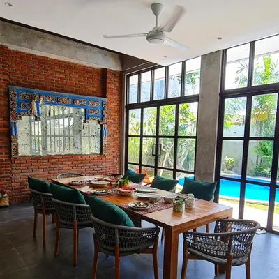 a dining room with a wooden table and chairs at Rumah Hadeka Petitenget in Seminyak
