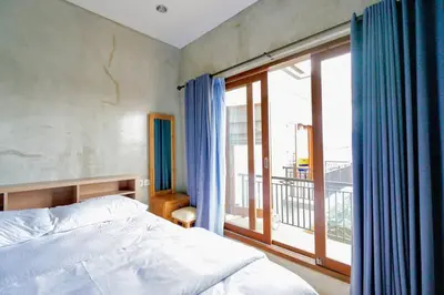 a bedroom with a bed and a large window at Villa Cleopatra Bali in Sanur