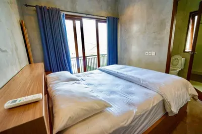 a large bed in a room with a window at Villa Cleopatra Bali in Sanur