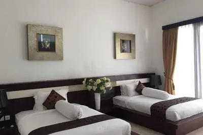 a hotel room with two beds and a window at Aldeoz Villa Nusa Dua in Nusa Dua