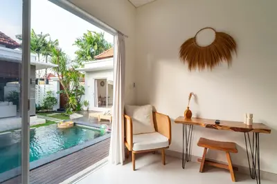 an office with a desk and a chair next to a pool at Villa Luna Rose in Seminyak